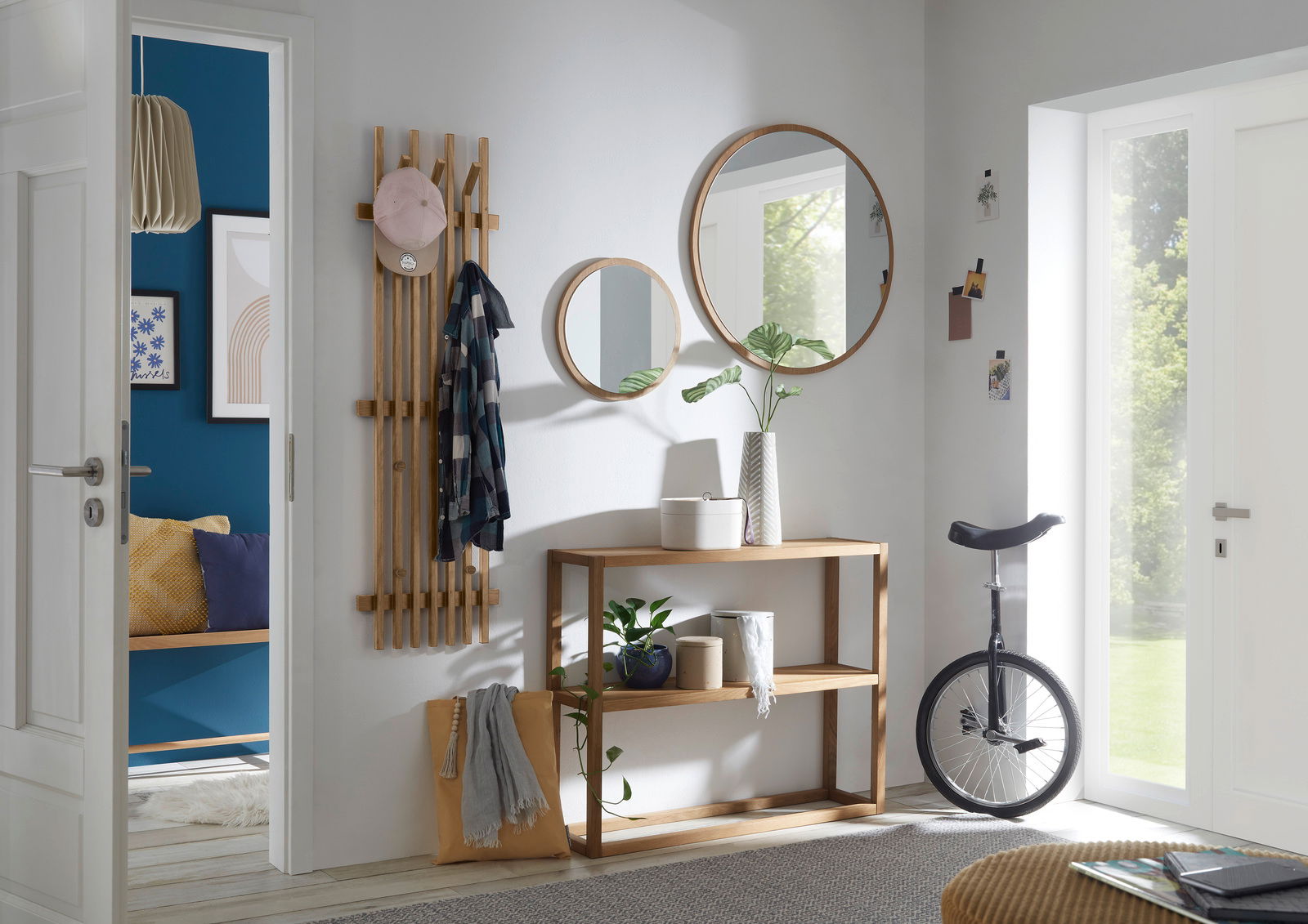 Linea Natura Spiegel BANTRY Moderner Eingangsbereich mit runden Spiegeln, Holzkonsole und Hakenleiste aus Holz, seitliche Perspektive.