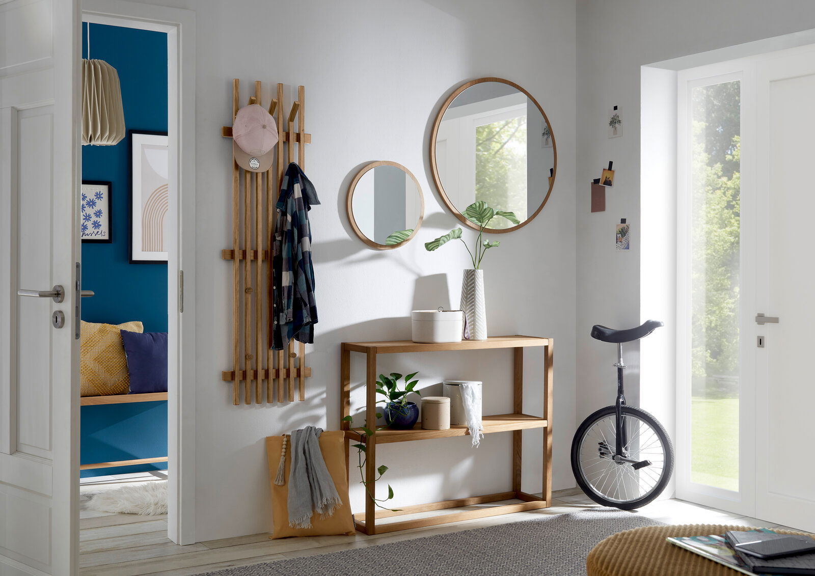 Linea Natura Spiegel BANTRY Moderner Eingangsbereich mit runden Spiegeln, Holzkonsole und Hakenleiste aus Holz, seitliche Perspektive.