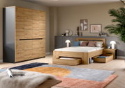 Modernes Schlafzimmer mit Bett aus hellem Holz inklusive ausziehbarer Schubladen und passendem Kleiderschrank, fotografiert in schräger Frontansicht aus leicht erhöhter Perspektive.