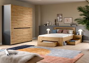 Modernes Schlafzimmer mit Bett aus hellem Holz inklusive ausziehbarer Schubladen und passendem Kleiderschrank, fotografiert in schräger Frontansicht aus leicht erhöhter Perspektive.