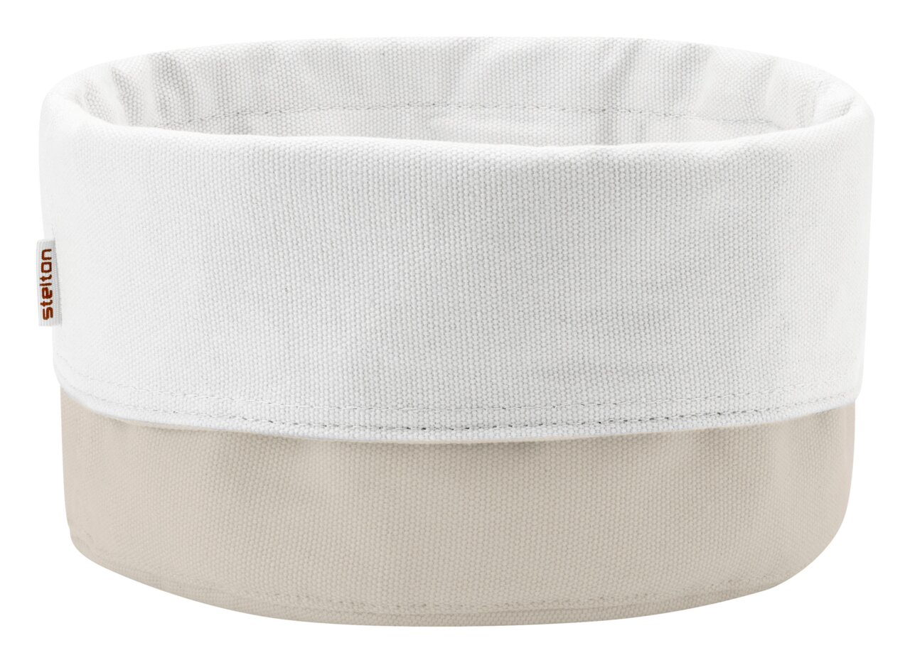 Runder Stoffkorb/Aufbewahrungskorb aus Canvas in Weiß und Beige mit umgeschlagenem Rand und kleinem „stelton“-Label, freigestellt vor weißem Hintergrund, Frontansicht