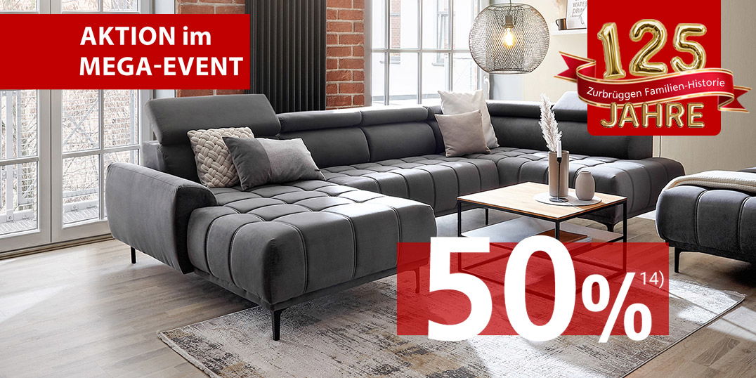 Graues Ecksofa in modernem Loft-Stil mit Zierkissen, Couchtisch und gemütlicher Wohnatmosphäre.