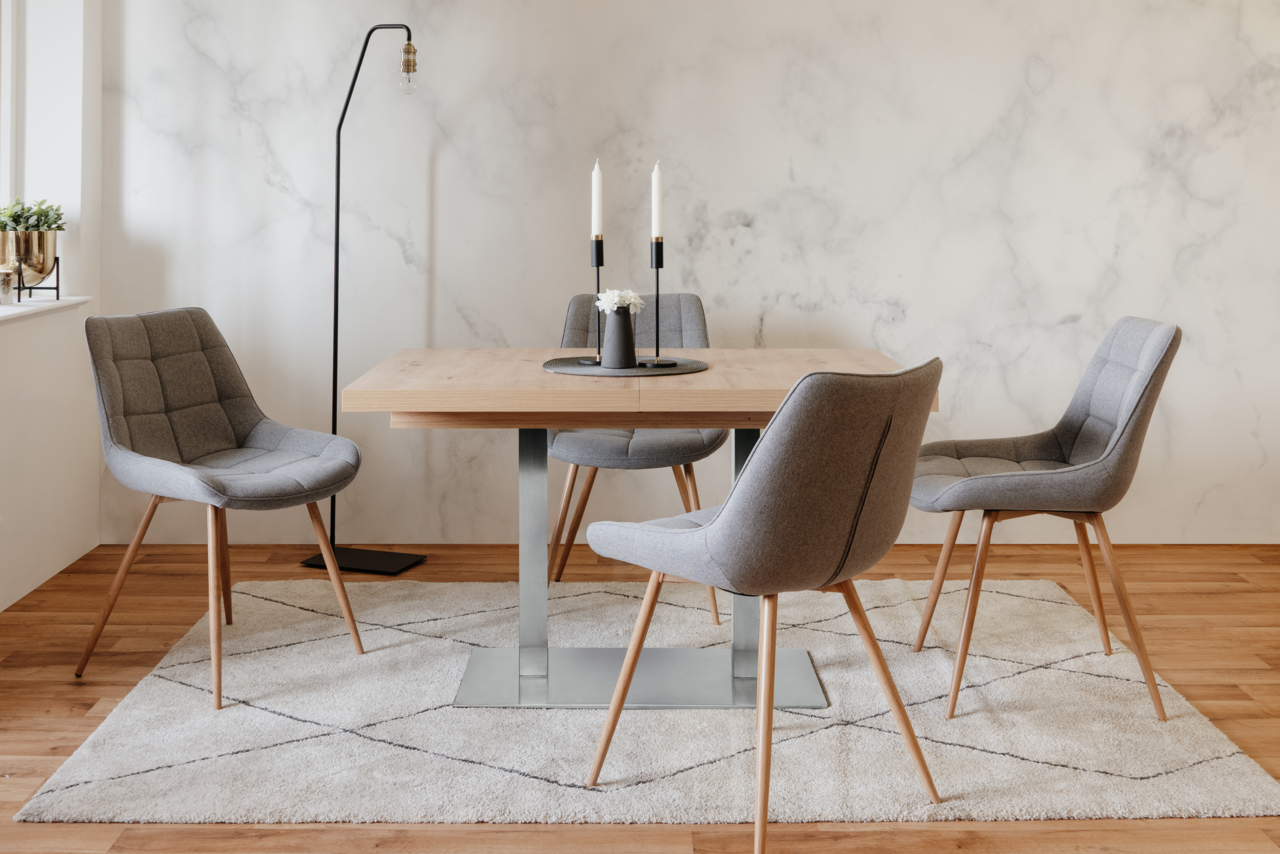 Z2 Funktions-Esstisch QUADRATO Moderner Esstisch mit Holzplatte und Metallgestell, umgeben von vier grauen Polsterstühlen, aus der Frontalperspektive fotografiert.