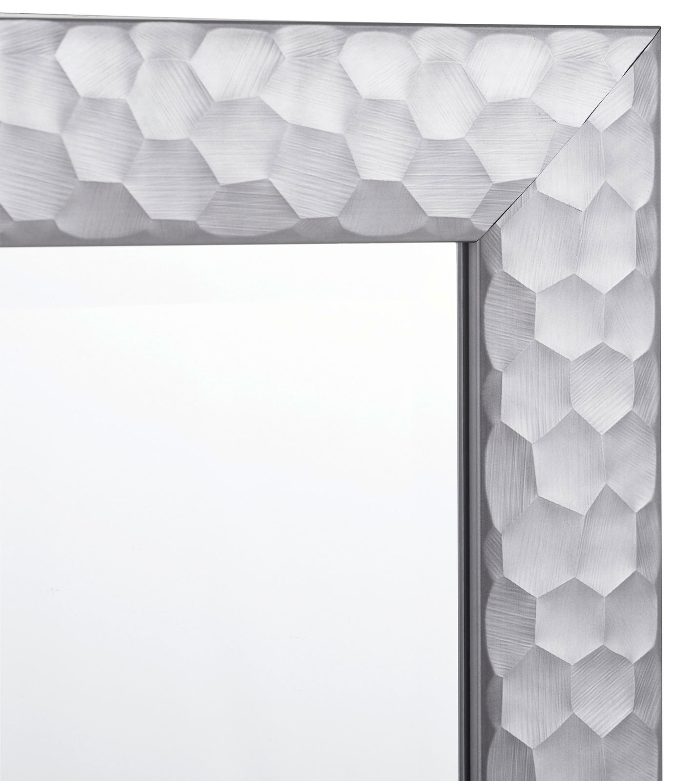 Nahaufnahme eines Spiegels mit einem silbernen, geometrisch gemusterten Rahmen, Perspektive von der Ecke.