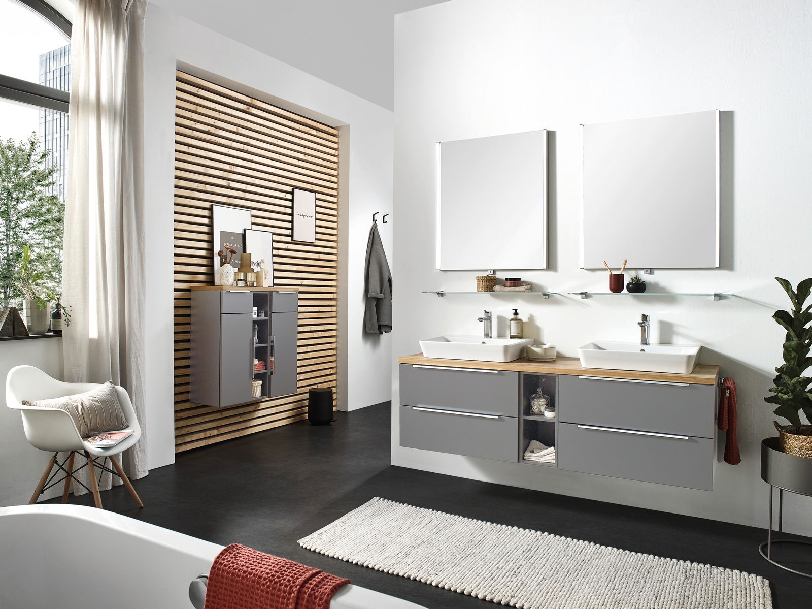 Moderne Badkombination mit zwei Waschbecken, grauen Schränken und großen Spiegeln, seitliche Perspektive