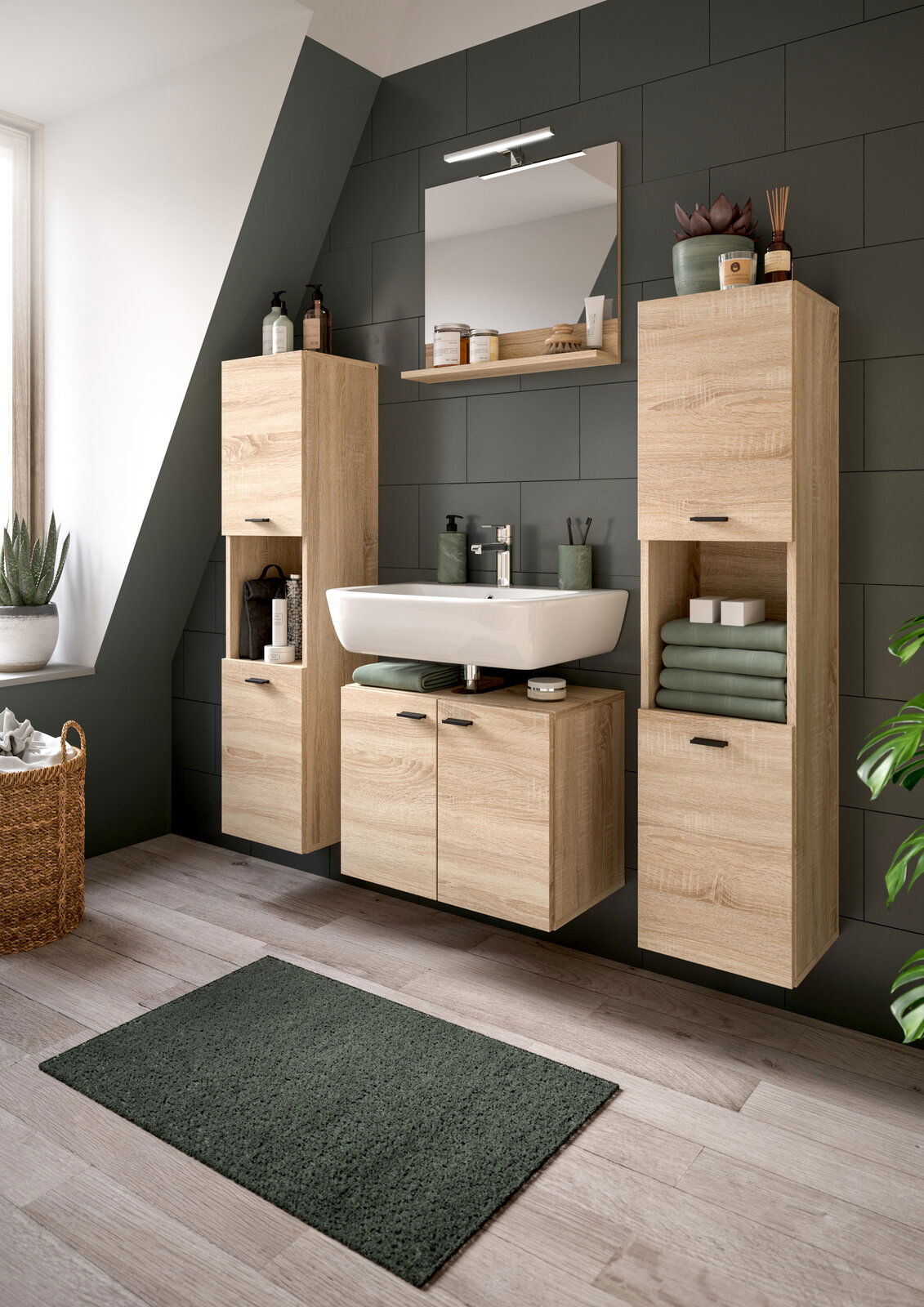 MID.YOU Badkombination BOSTON Moderne Badkombination mit Holzoptik, bestehend aus einem Waschbecken mit Unterschrank, zwei hohen Schränken und einem Spiegel, aus der Perspektive eines hellen Badezimmers mit Dachschräge.