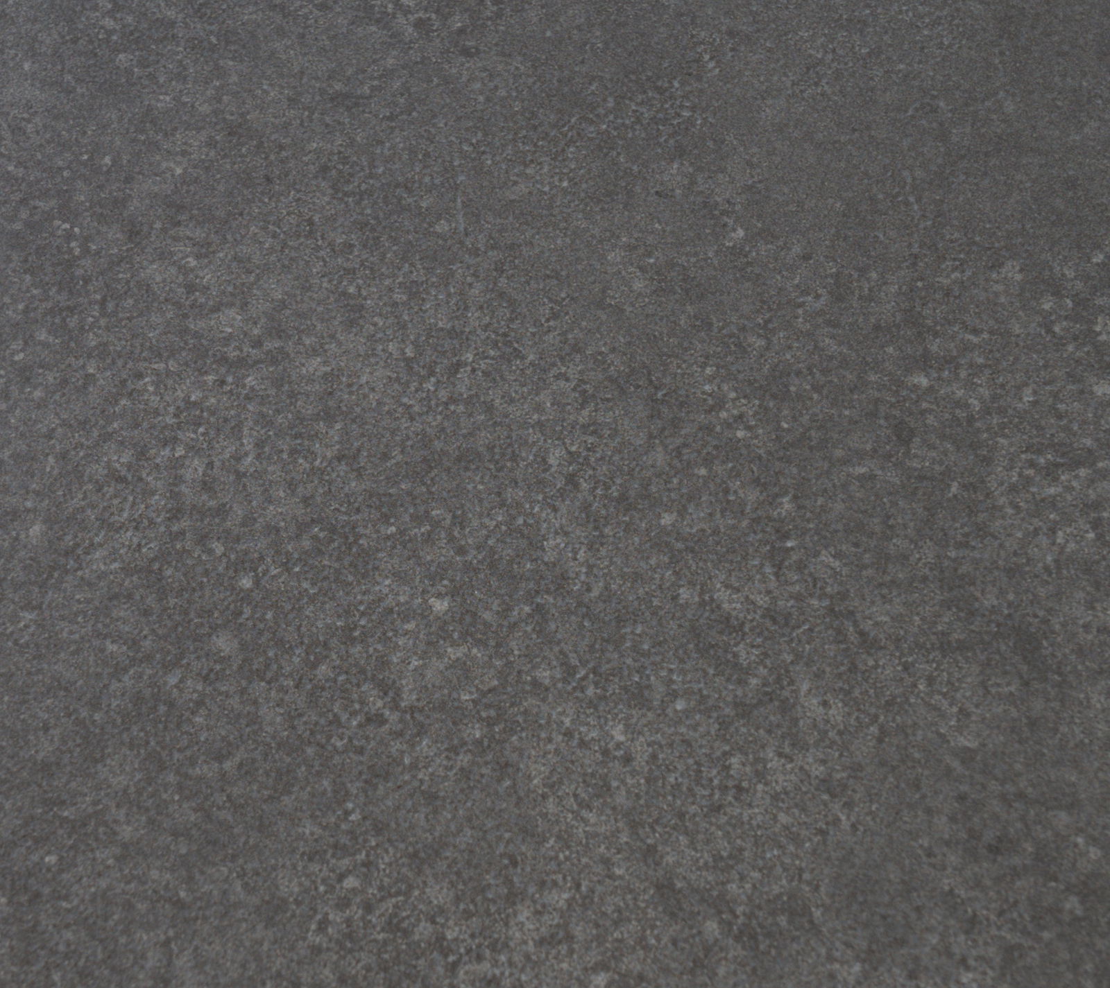 Nahaufnahme der dunklen, strukturierten Oberfläche eines Beistelltisches