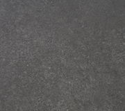 Nahaufnahme der dunklen, strukturierten Oberfläche eines Beistelltisches