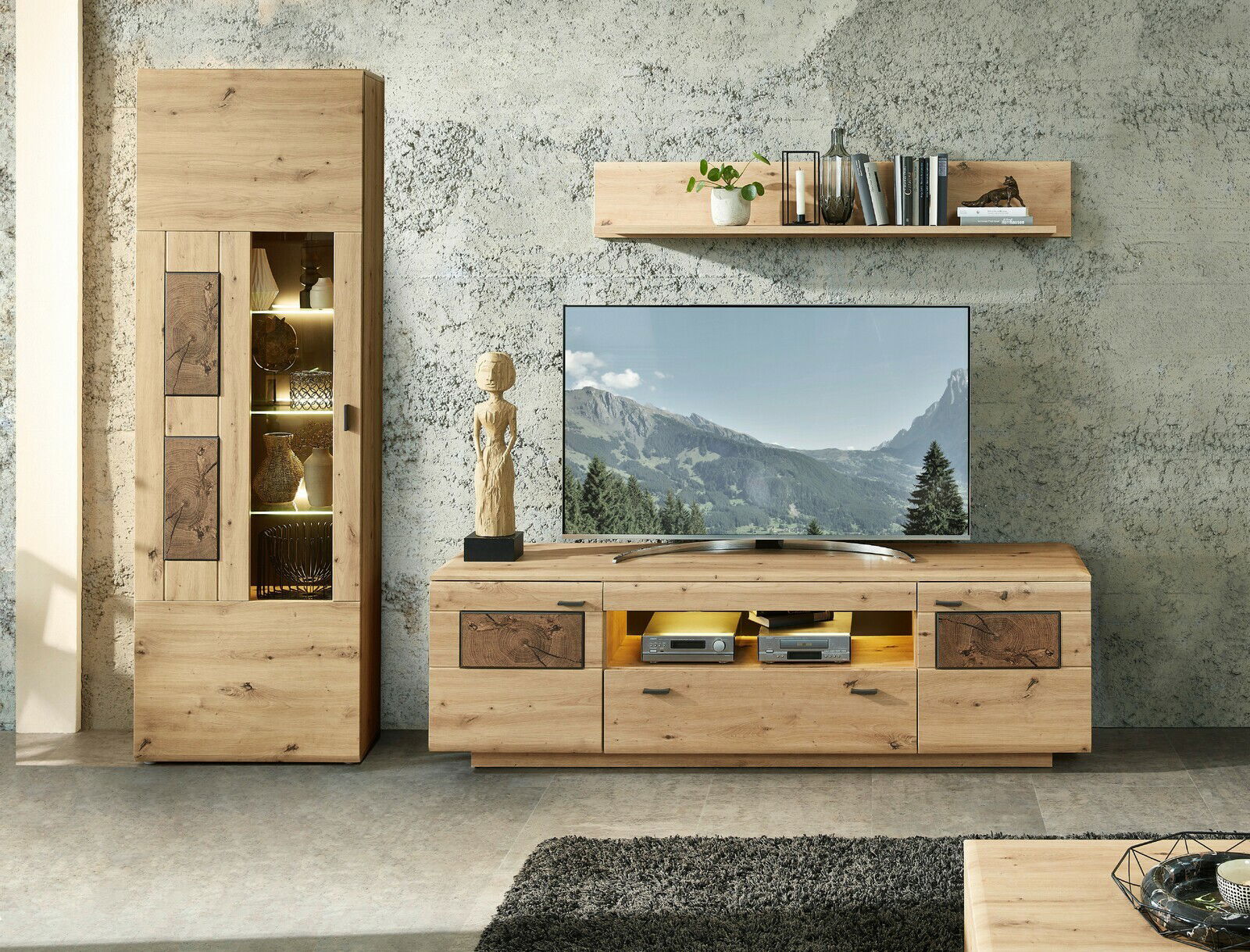 Wandkombination MADERA II aus Holz in moderner Wohnzimmerumgebung, bestehend aus einem hohen Schrank, einem TV-Board und einem Wandregal, frontal betrachtet.