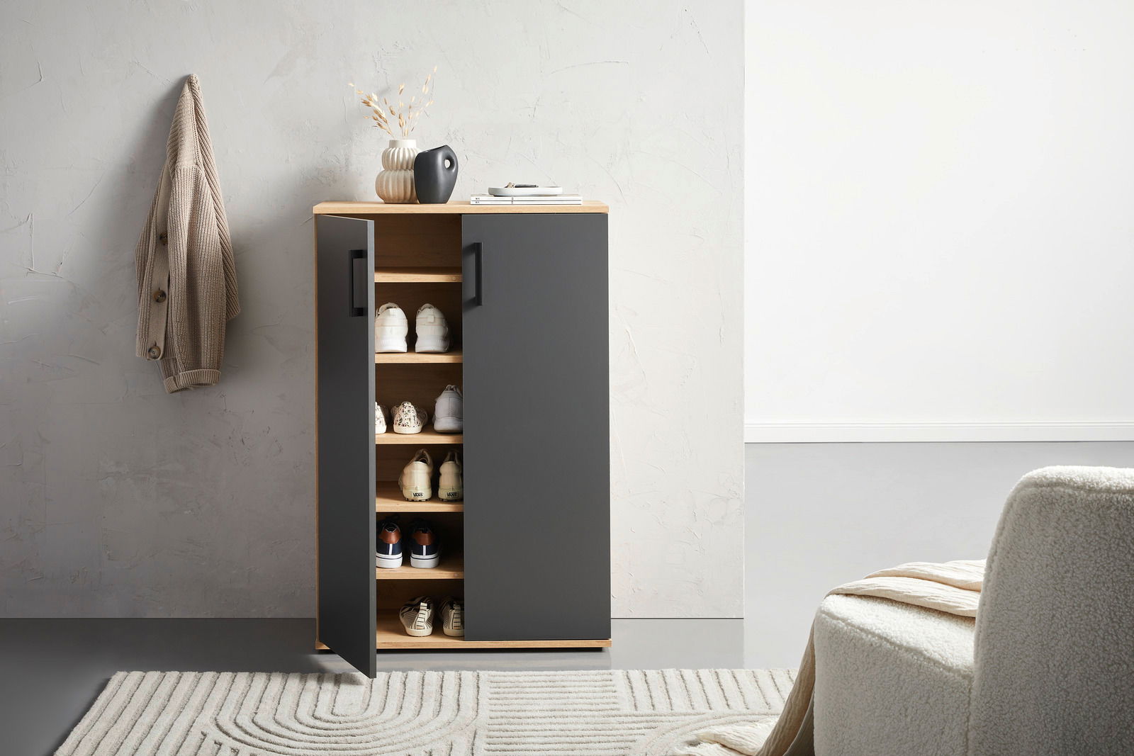 Moderner Schuhschrank mit schwarzer Front und Holzregalen, teilweise geöffnete Tür, seitliche Perspektive