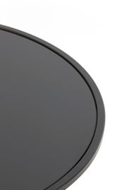 Nahaufnahme eines runden, schwarzen Couchtischs mit glatter Oberfläche, von oben betrachtet.