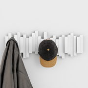 Moderne Wandgarderobe mit geometrischem Design, frontal fotografiert, mit einem Mantel und einer Kappe aufgehängt.