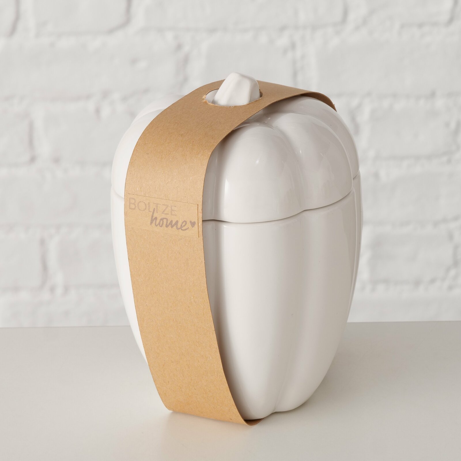 Weißer Jumbobecher in Form eines Kürbisses mit braunem Papierband, seitliche Perspektive.