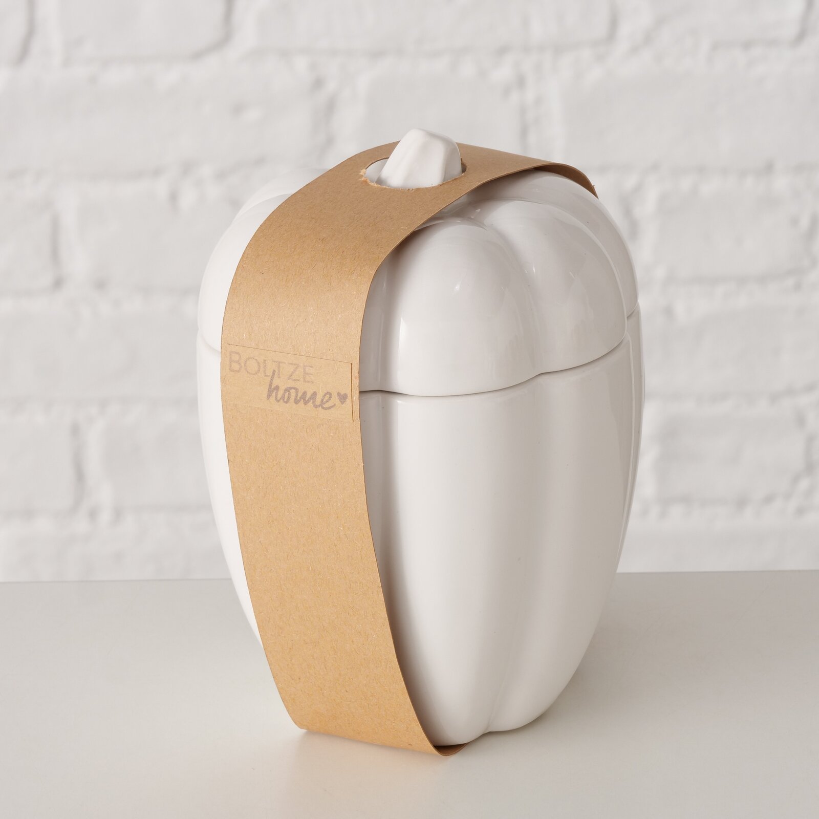 Weißer Jumbobecher in Form eines Kürbisses mit braunem Papierband, seitliche Perspektive.