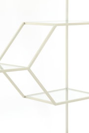 Close-up van een moderne, geometrische staande boekenkast met glazen planken en een wit metalen frame, gezien vanaf de zijkant.