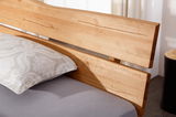 Nahaufnahme eines Balkenbetts aus Holz mit Kopfteil, seitliche Perspektive