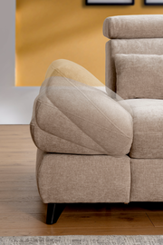 Nahaufnahme einer beigen Rundecke mit verstellbarer Armlehne, seitliche Perspektive.