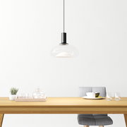 Moderne Hängeleuchte aus Glas über einem Esstisch, seitliche Perspektive