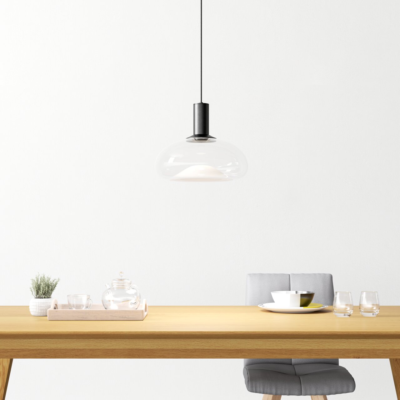 Moderne Hängeleuchte aus Glas über einem Esstisch, seitliche Perspektive
