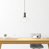 Moderne Hängeleuchte aus Glas über einem Esstisch, seitliche Perspektive