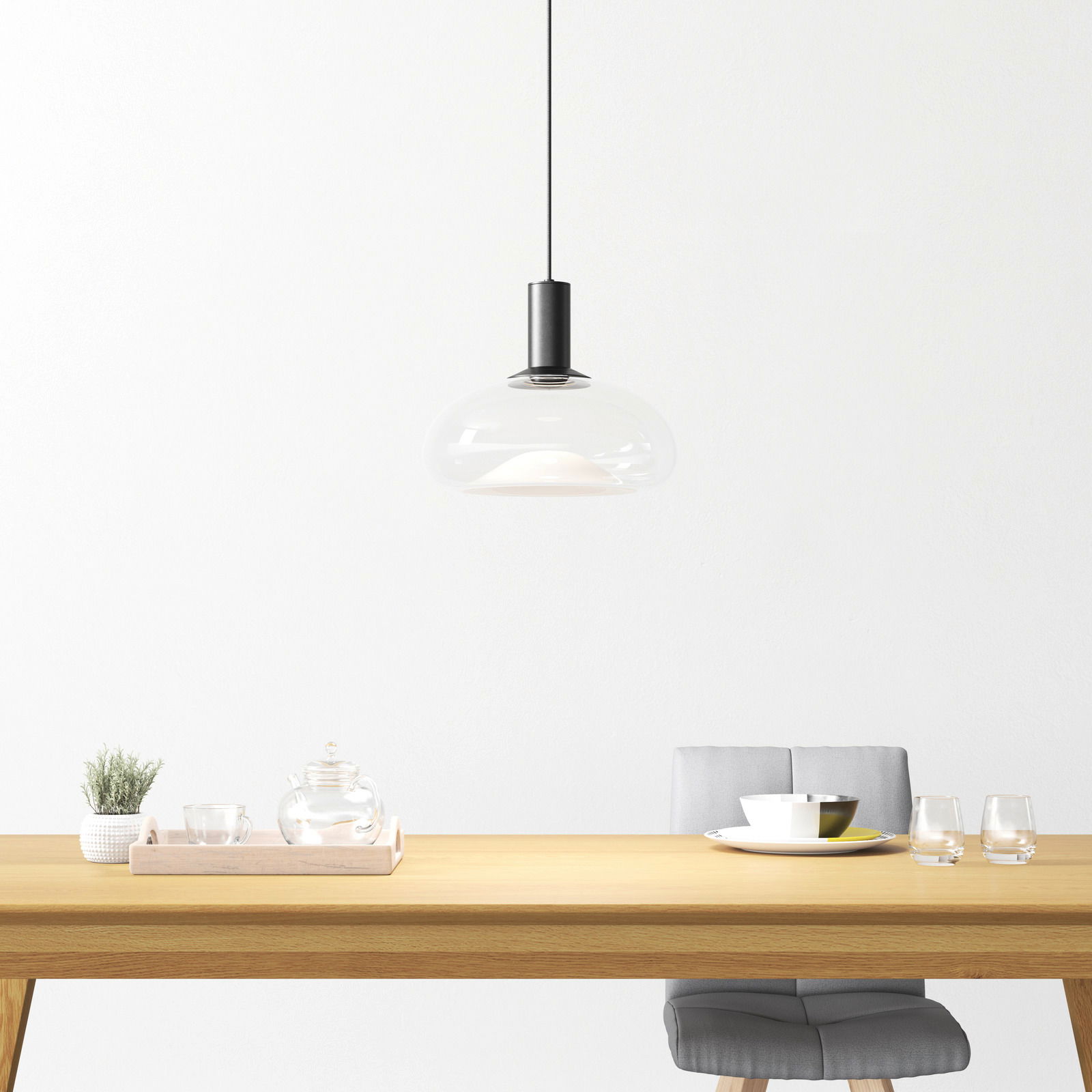Moderne Hängeleuchte aus Glas über einem Esstisch, seitliche Perspektive