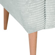 Detailaufnahme eines hellgrauen, gerippten Polstermöbels mit konischen Holzbeinen, schräg von unten an der Ecke fotografiert