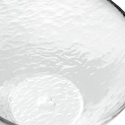 Nahaufnahme einer transparenten, strukturierten Glasschale mit wellenförmiger Oberfläche, von oben betrachtet.