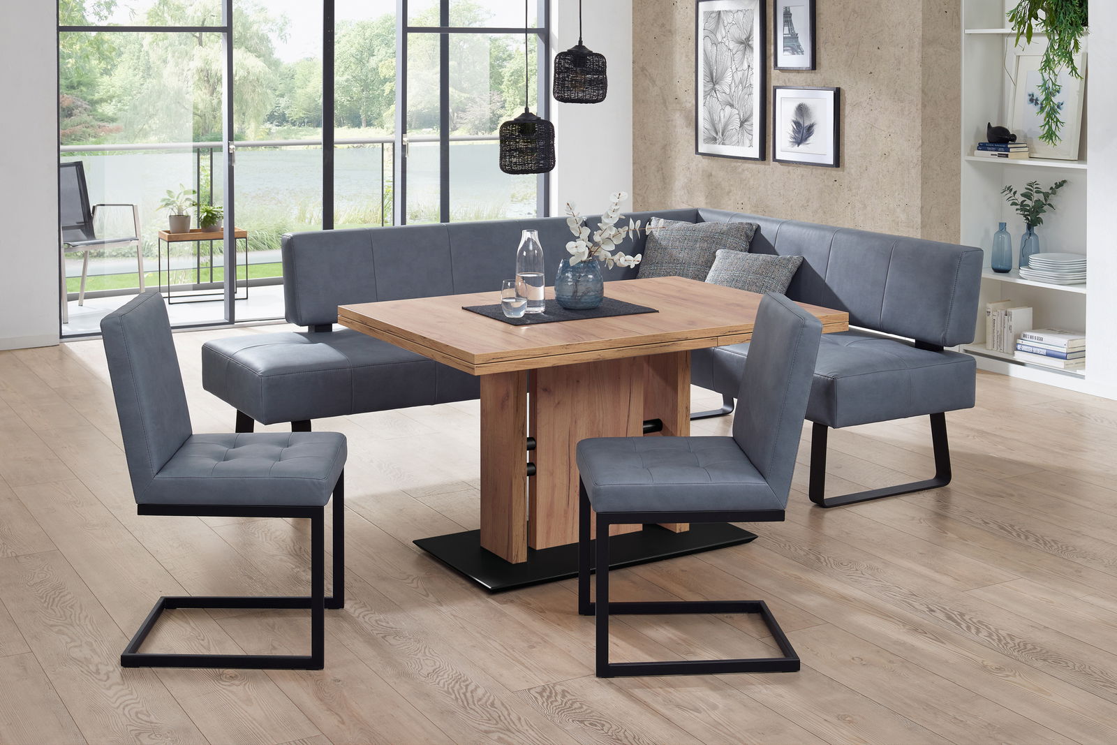 Moderano Esstisch LUPO II Moderne Essgruppe mit Eckbank und Freischwinger-Stühlen in grauem Stoff, kombiniert mit einem Holztisch. Die Perspektive zeigt die Essgruppe in einem hellen Raum mit großen Fenstern im Hintergrund.
