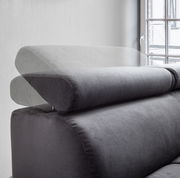 Verstellbare Kopfstütze einer grauen Polsterrundecke, seitliche Perspektive mit Fenster im Hintergrund.