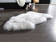 Schaffell in wollweiß auf einem Holzboden, seitliche Perspektive