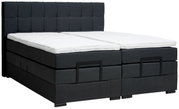 Boxspringbett in dunklem Stoffbezug mit gestepptem Kopfteil, seitliche Perspektive