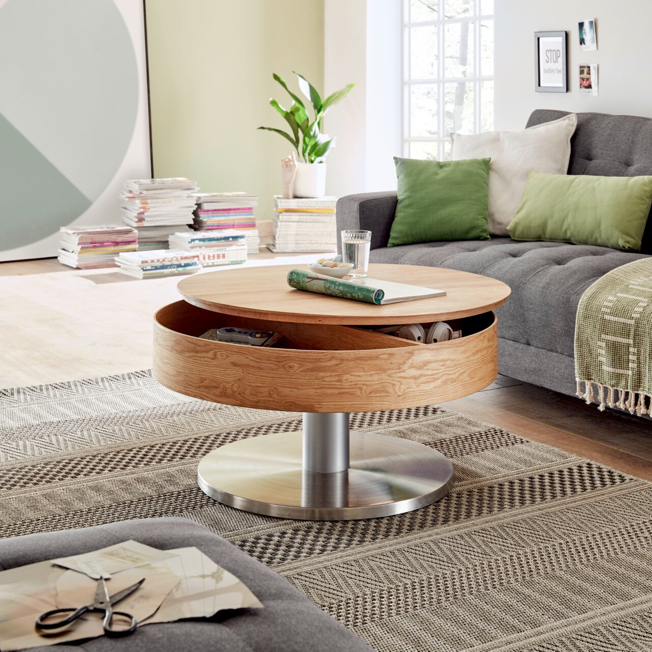 Zurbrüggen Salontafel SUVA Moderne houten salontafel met een rond ontwerp en ingebouwde opbergruimte, staande op een metalen voet, in een gezellige woonkamer met bank en decoraties, gezien vanuit de zijkant.