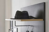 Garderobenpaneel mit schwarzem Hut auf einem Holzregal, seitliche Perspektive