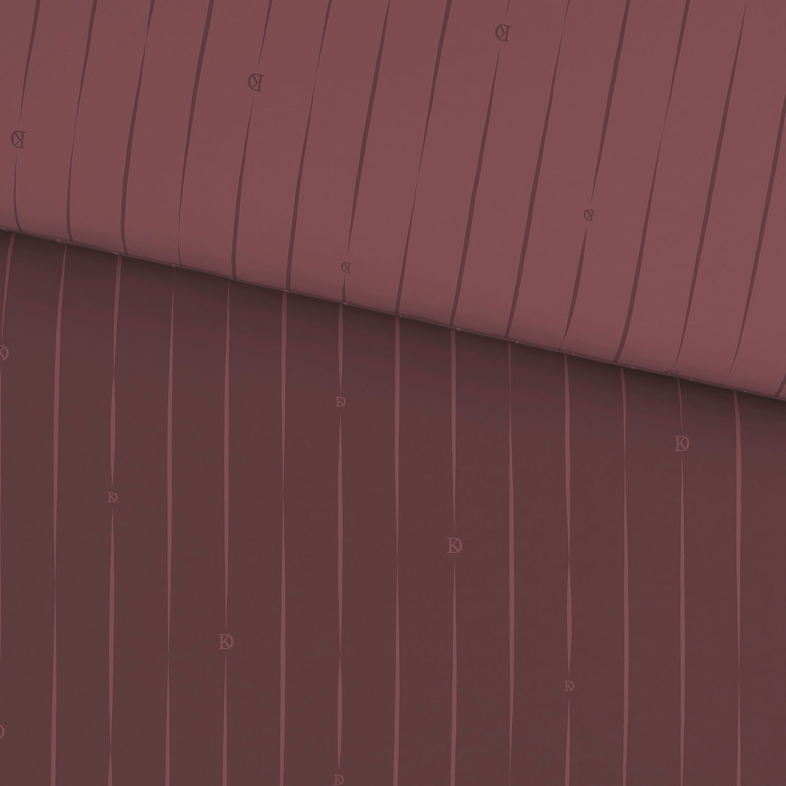 Nahaufnahme einer Wendebettwäsche in dunklem Rot mit feinen vertikalen Streifen und kleinen Buchstabenmotiven.