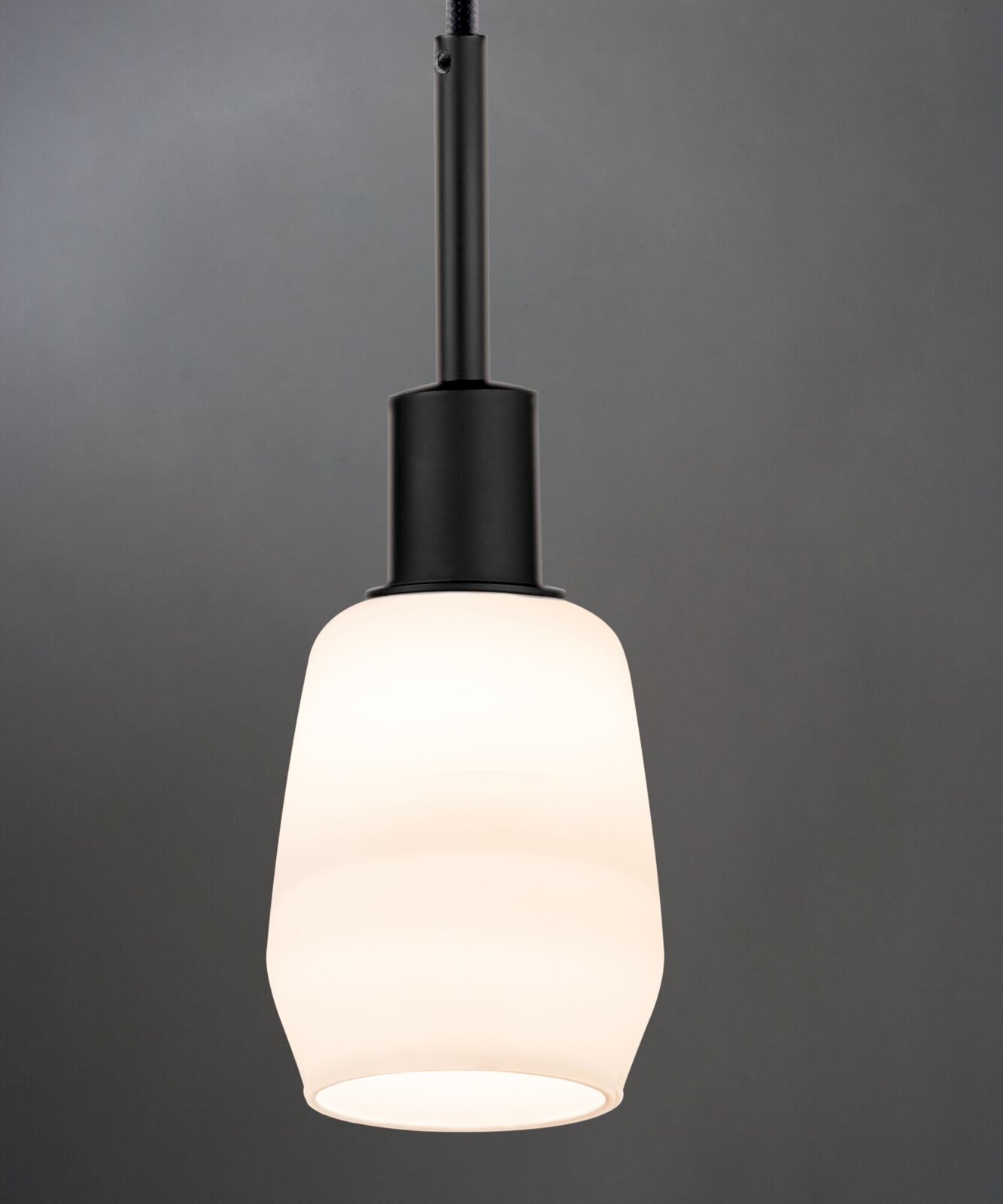Moderne Hängelampe mit schwarzem Sockel und weißem, mattem Glasschirm, seitliche Perspektive