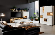 Moderne woonkamermeubels met een wit hoogkast, dressoir en wandplank, ledverlichting, planten en decoraties, gezien vanuit de zijkant.