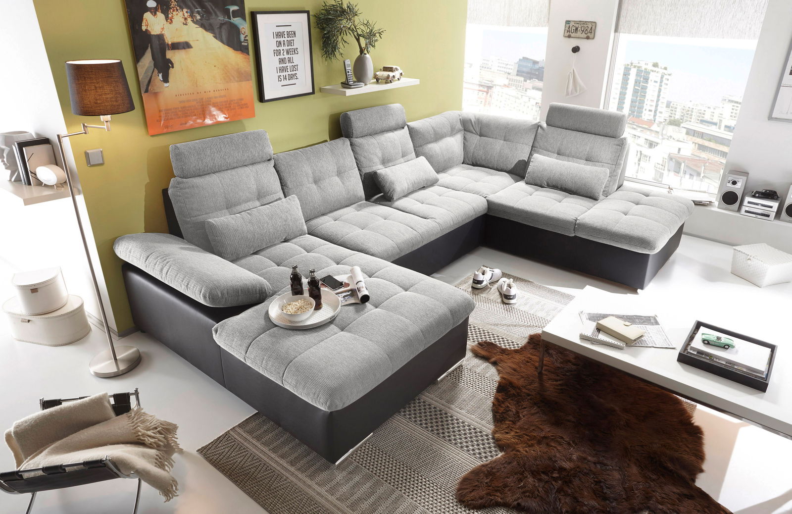 Moderne graue U-förmige Wohnlandschaft in einem hellen Wohnzimmer, seitliche Perspektive