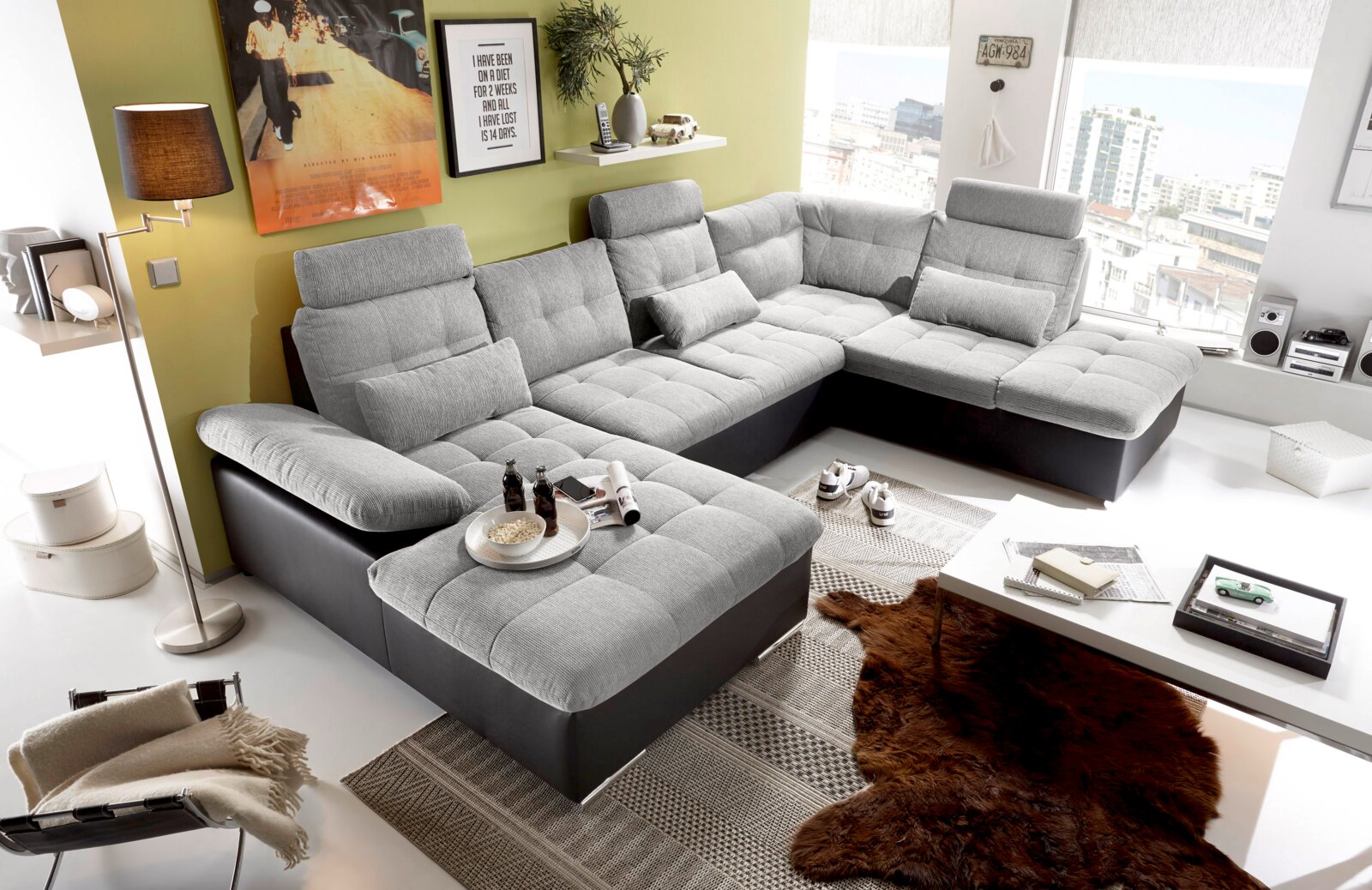 Moderne graue U-förmige Wohnlandschaft in einem hellen Wohnzimmer, seitliche Perspektive