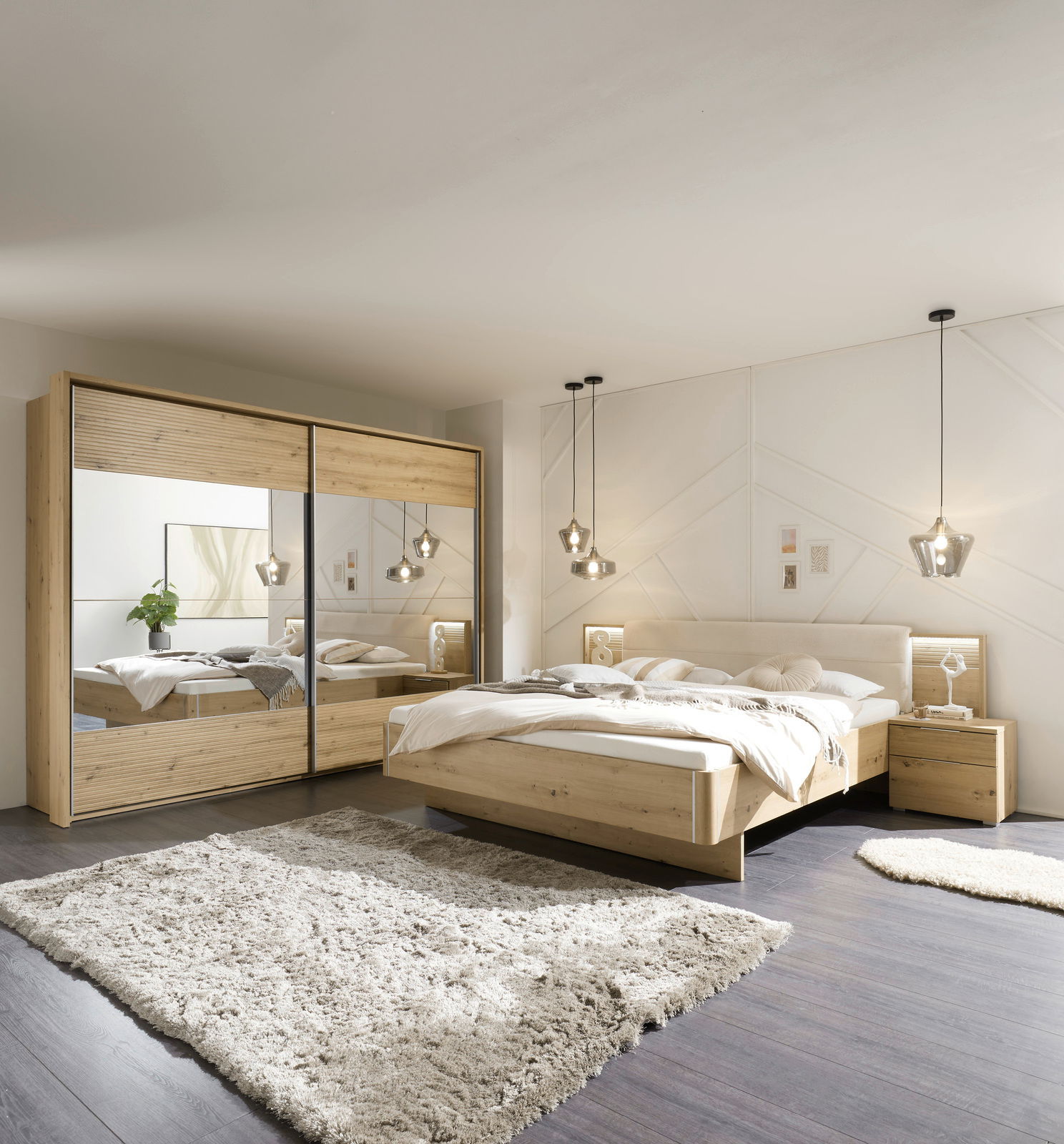 Moderne Schlafzimmeransicht mit einem großen Holzbett, flankiert von Nachttischen, und einem Kleiderschrank mit Spiegeltüren. Die Perspektive zeigt das Zimmer von vorne, mit einem weichen Teppich auf dunklem Holzboden und stilvollen Hängelampen.