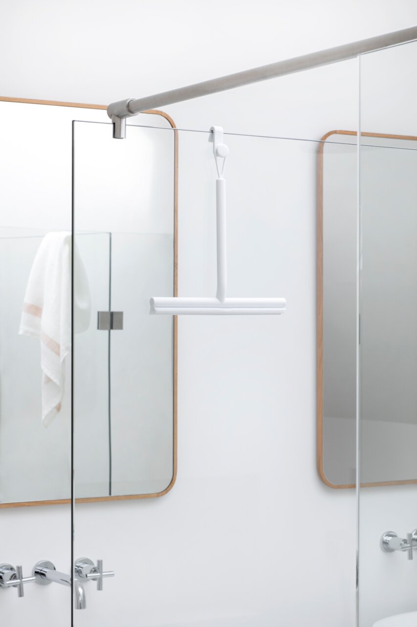 Brabantia Duschkabinenabzieher MINDSET Weißer Duschkabinenabzieher, der an einer Glasduschwand hängt, seitliche Perspektive.