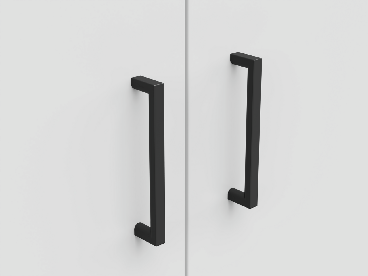 Nahaufnahme von zwei schwarzen Griffen an einer weißen Schranktür, frontal betrachtet.