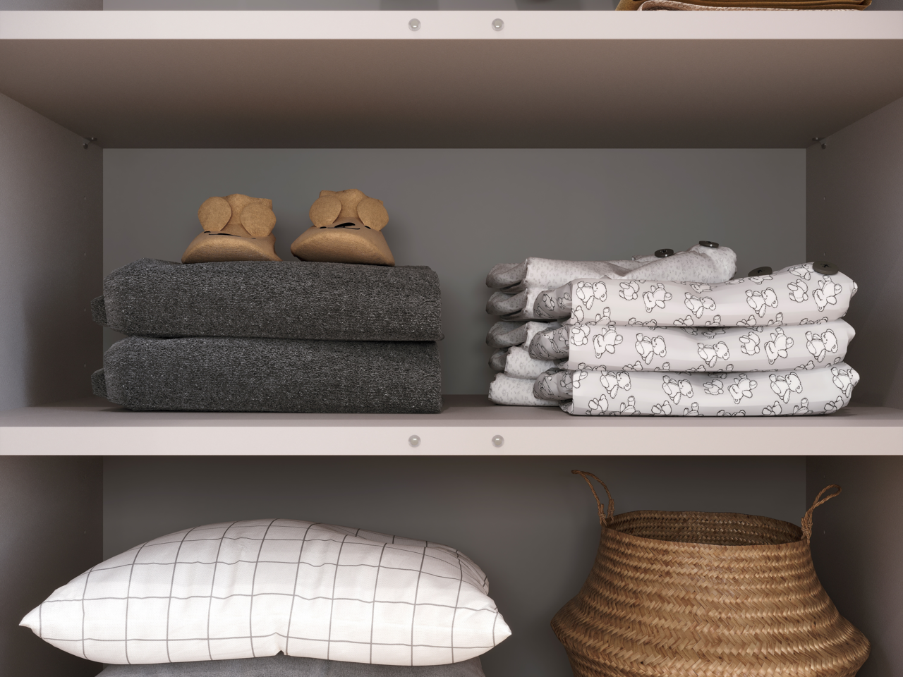 Nahaufnahme eines Regals einer breiten Kommode mit gefalteten Handtüchern, Kinderkleidung und einem geflochtenen Korb.