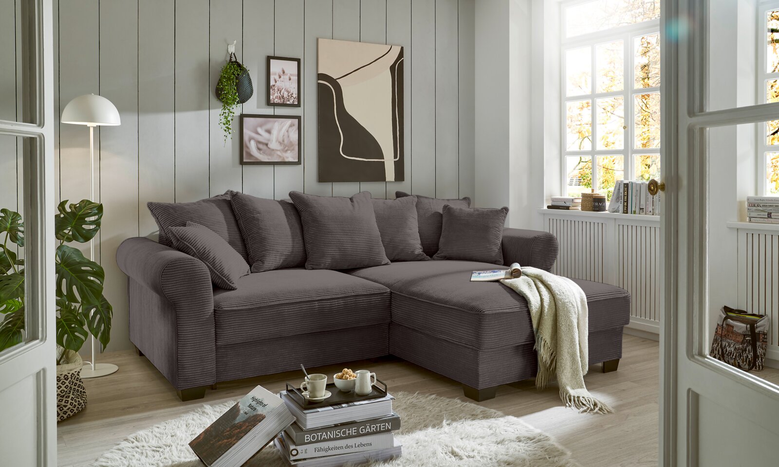 Hom´in Ecksofa MAUREEN Gemütliche graue Rundecke in einem hellen Wohnzimmer, seitliche Perspektive