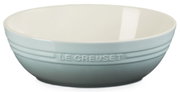 Hellblaue Le Creuset Keramikschüssel mit geprägtem Logo und weißer Innenfläche, seitliche Frontansicht vor weißem Hintergrund