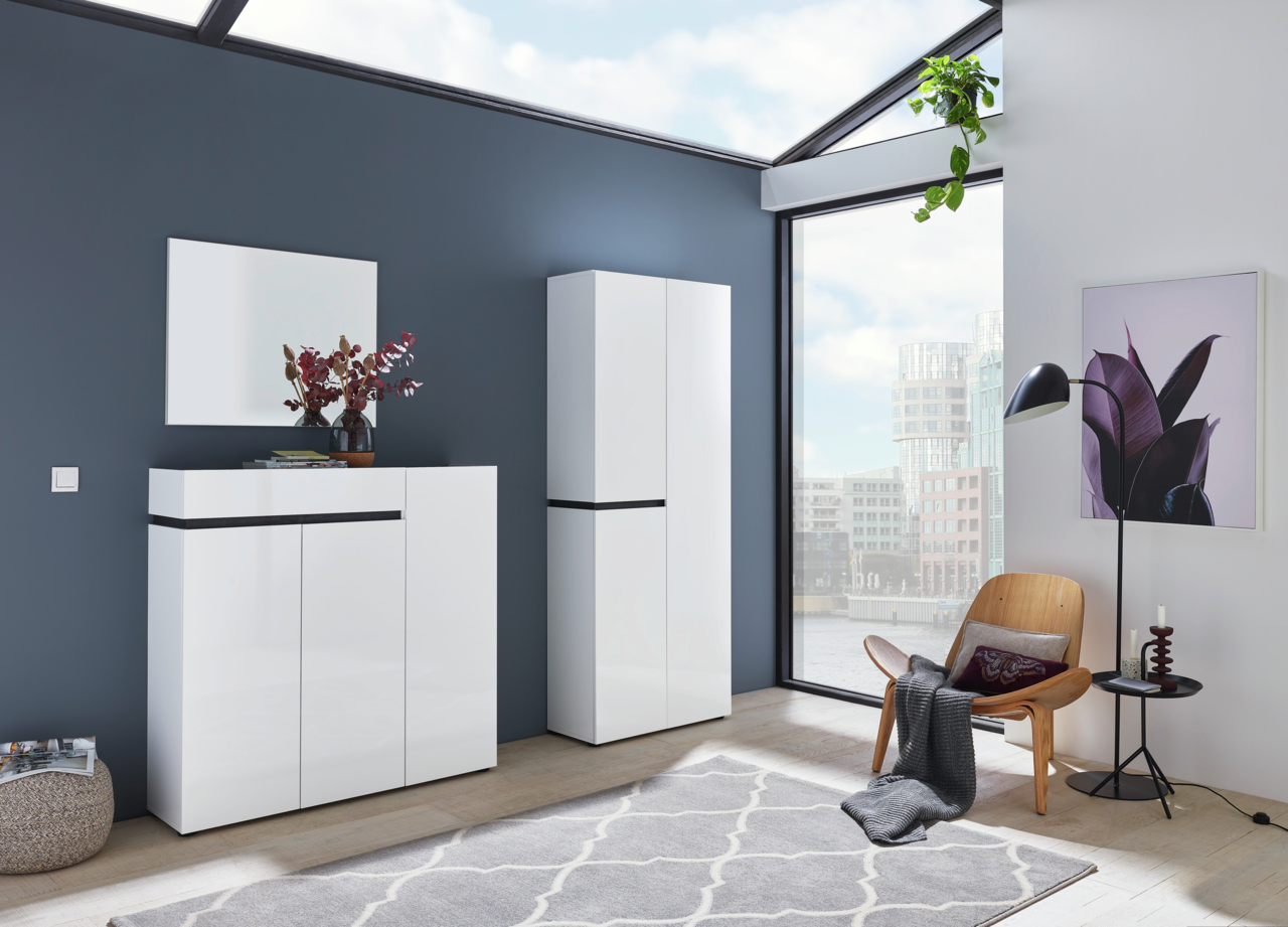 Voleo XL-Schuh-/Mehrzweckschrank YES Moderner weißer Schuhschrank und Garderobenschrank in einem hellen Raum mit großen Fenstern, seitliche Perspektive