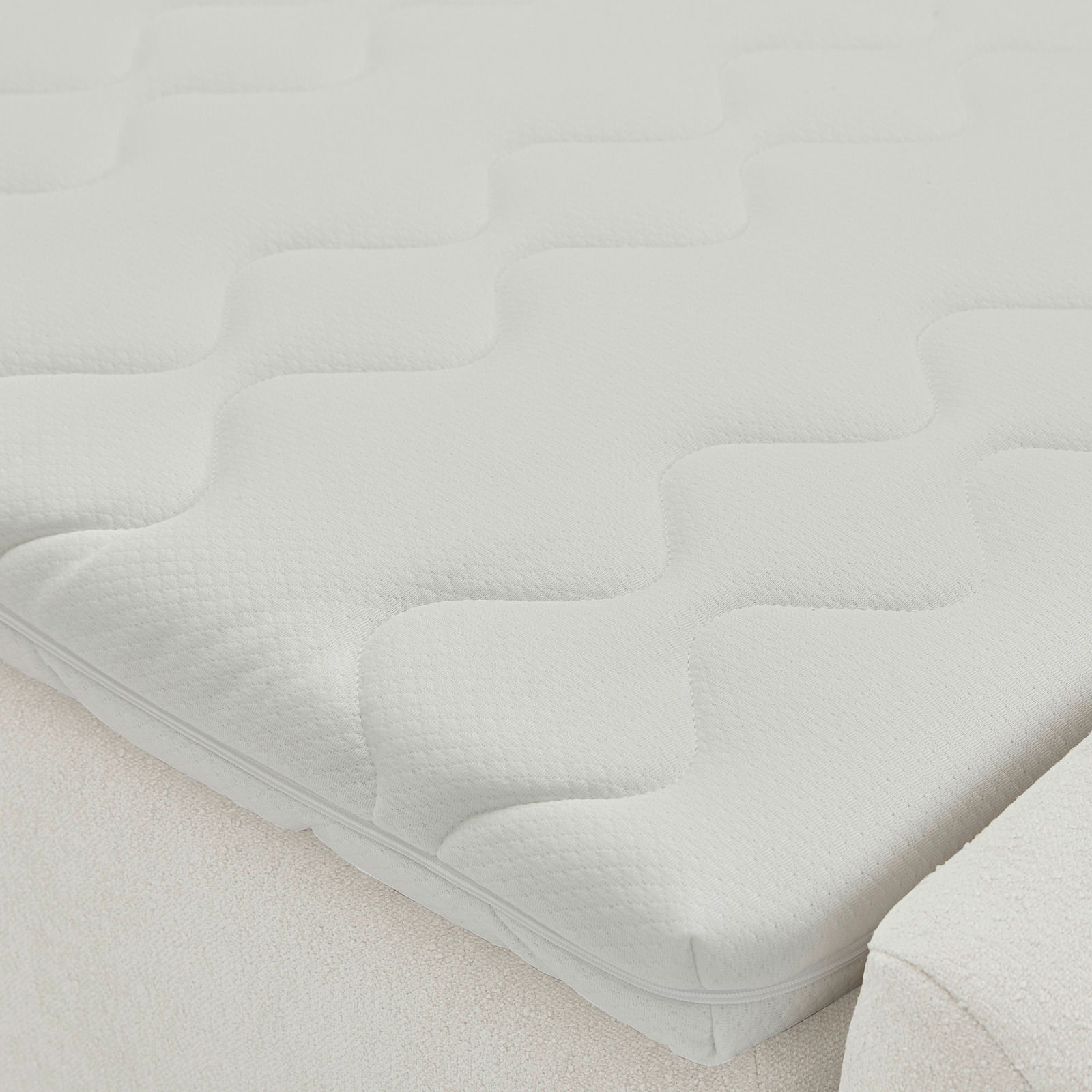 Nahaufnahme einer weißen Matratze mit wellenförmigem Muster auf einem Boxbett, seitliche Perspektive