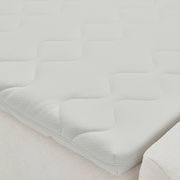 Nahaufnahme einer weißen Matratze mit wellenförmigem Muster auf einem Boxbett, seitliche Perspektive