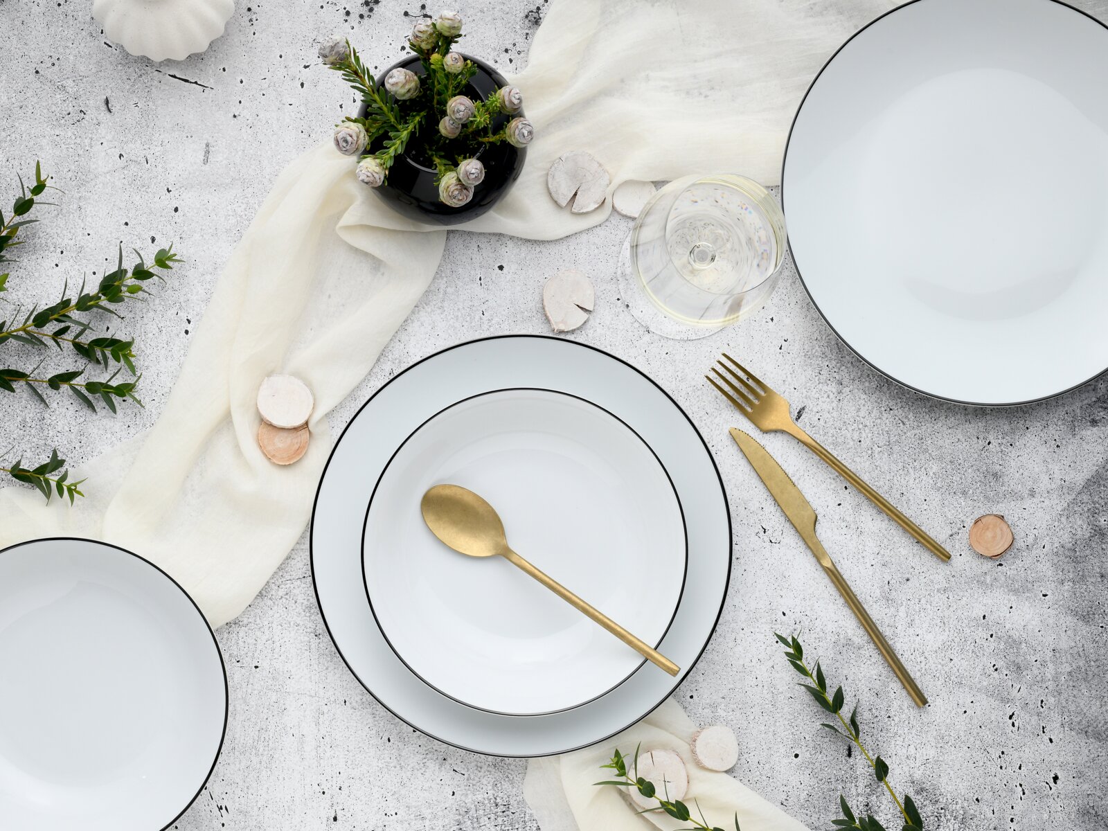 creaTable Tellerset 18-tlg LUNA Elegantes 18-teiliges Tellerset mit feinem schwarzem Rand, goldfarbenem Besteck und dekorativen Elementen, aus der Vogelperspektive aufgenommen.