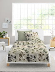 Bettwäsche-Set 155x220cm mit Blättermuster in natürlichen Farben, auf einem weißen Bett in einem hellen Raum mit großen Fenstern, aus der Vorderansicht fotografiert.