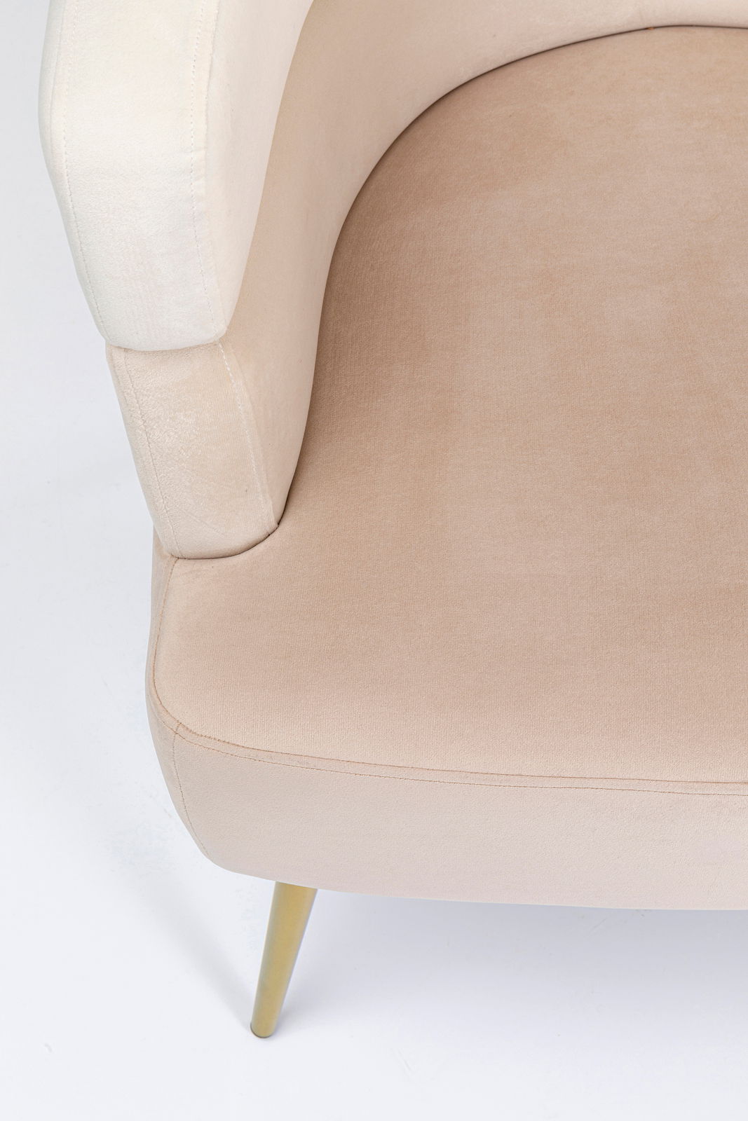 Nahaufnahme eines beigen Sessels mit goldenen Beinen, von oben betrachtet.
